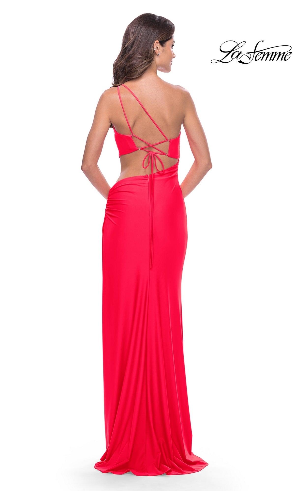 A woman faces away from the camera in the La Femme Long Prom Dress 31443, a bright red, fitted, floor-length gown with an open strappy back and smooth finish that highlights its elegant silhouette.